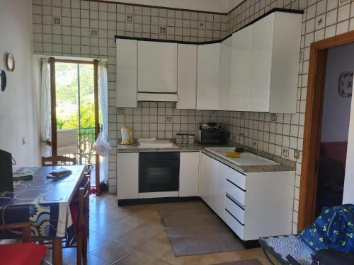 a kitchen with white cabinets and a table in a room at Casa Del Fico in Montecorice