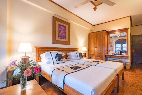 Hotel Casamara في كاندي: غرفة نوم بسريرين وطاولة