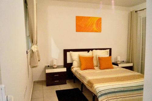 a bedroom with a bed with orange pillows at EL Paraiso in La Pared