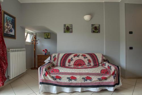 a room with a bed with a blanket on it at The house in red: per un soggiorno pieno di vitalità:mare,sole,passeggiate in Imperia