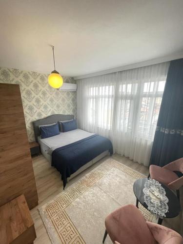 Smf Suites 2+1 5 Luxery Flat Good Location في إسطنبول: غرفة نوم بسرير واريكة وكراسي