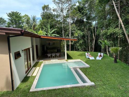 una piscina en un patio junto a una casa en New Private Pool Villa, en Baan Tai