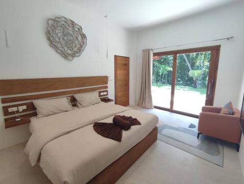 1 dormitorio con cama grande y ventana grande en New Private Pool Villa, en Baan Tai