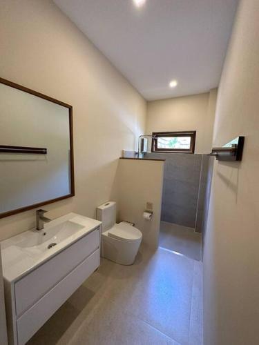 a bathroom with a sink and a toilet and a mirror at New Private Pool Villa in Ban Tai