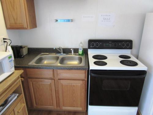 a small kitchen with a stove and a sink at Yellowstone Country Inn in West Yellowstone