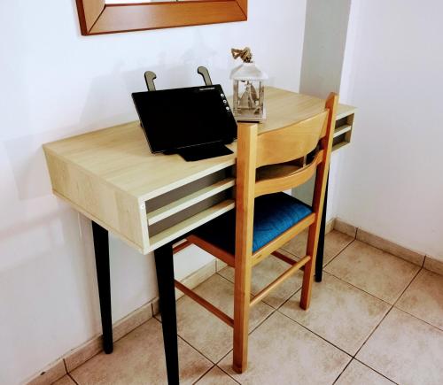 a wooden desk with a chair and a laptop at IRIS STUDIOS in Agios Nikitas