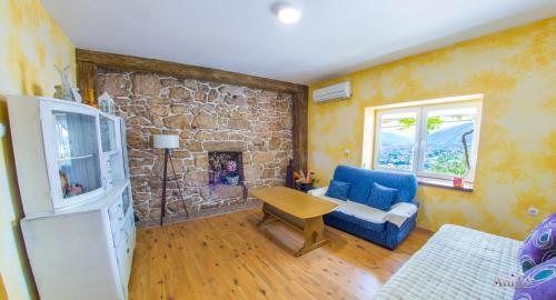 a living room with a blue couch and a stone wall at Perfect view of Mostar - with swimming pool in Mostar