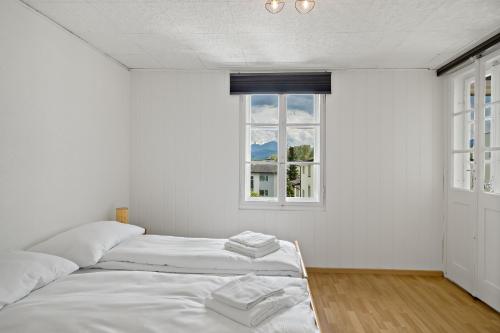 two beds in a room with a window at Erlen Rooms in Lucerne