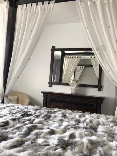 a bedroom with a bed and a mirror at Cleomack House in Hilltown