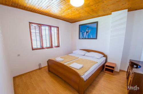 a bedroom with a bed with white walls and a wooden ceiling at Perfect view of Mostar - with swimming pool in Mostar