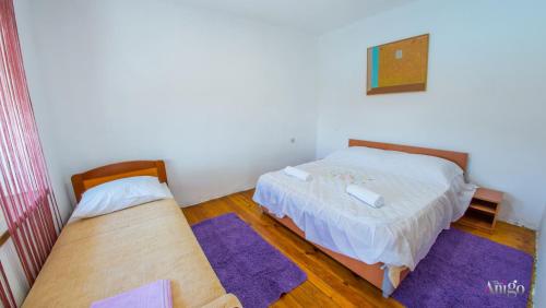 two beds in a small room with purple rugs at Perfect view of Mostar - with swimming pool in Mostar