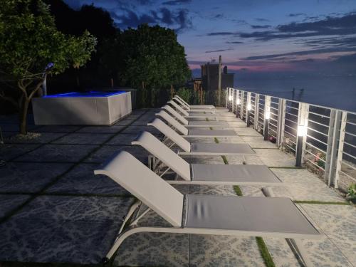 a row of white benches sitting on a sidewalk at night at Relais al Castello in Castellammare di Stabia