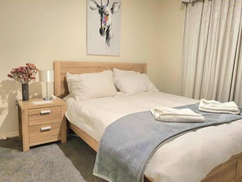 a bedroom with two beds and a nightstand with a deer picture at Spacious Home in West Moonah, Hobart in Moonah