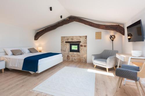 een slaapkamer met een bed, een tafel en een stoel bij Villa Vittorina - New Rental in Svetvinčenat