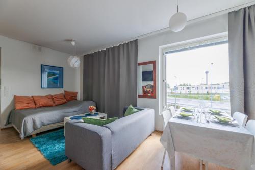 ein Wohnzimmer mit einem Sofa, einem Tisch und einem Bett in der Unterkunft Close to center and Näsijärvi Lake - free parking, AC, and two double beds in Tampere