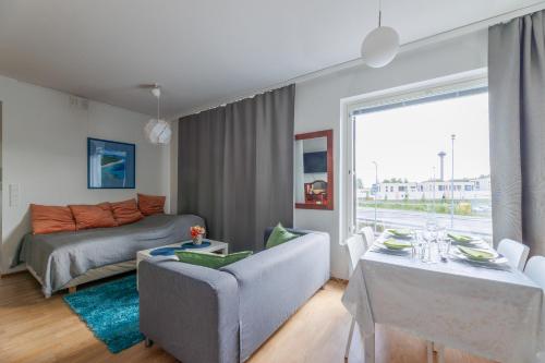 a living room with a couch and a table and a bed at Close to center and Näsijärvi Lake - free parking, AC, and two double beds in Tampere
