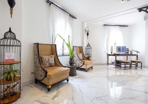 a living room with chairs and a bird cage at Le Thatluang D'oR Boutique Hotel in Vientiane
