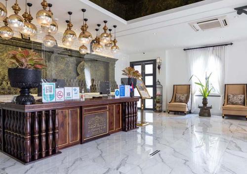 a lobby with a reception desk and chandeliers at Le Thatluang D'oR Boutique Hotel in Vientiane