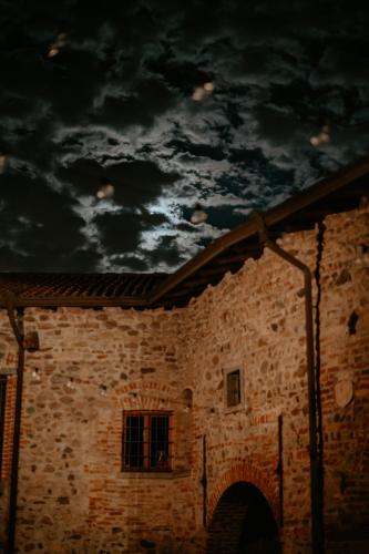 a brick building with a cloudy sky above it at Castello di Cernusco Lombardone in Cernusco Lombardone