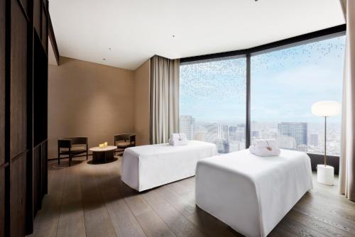 a hotel room with two beds and a large window at BELLUSTAR TOKYO, A Pan Pacific Hotel in Tokyo