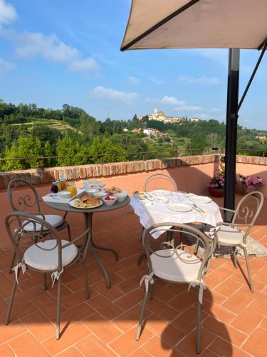 a patio with two tables and chairs and an umbrella at Agriturismo Due Comuni in San Gervasio