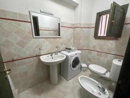 a bathroom with a sink and a washing machine at La Casa Del Borgo Cavallaro in Gaggi