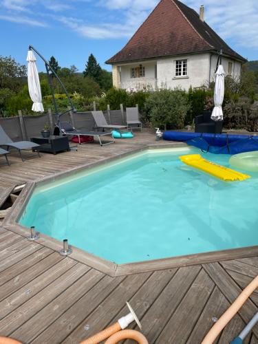une grande piscine sur une terrasse en bois dans l'établissement gite de la croix, à Saint-Léon-sur-Vézère