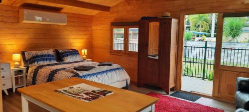 a bedroom with a bed and a table in a room at Churchill Cabin in Maryborough