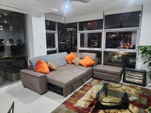 a living room with a couch with orange pillows at Bondi Junction Beauty in Sydney