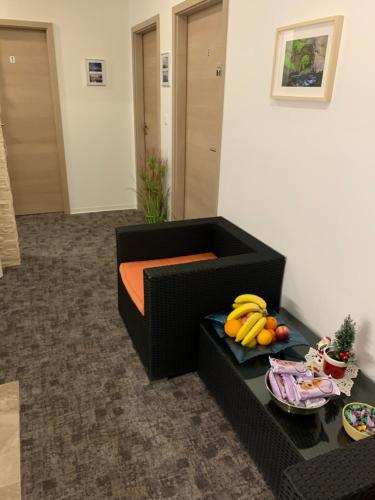 a black couch with fruit on a table in a room at L&G ROOMS in Ljubljana