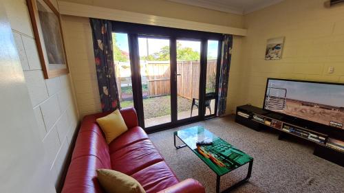 a living room with a couch and a tv at Rise n' Shine - min stay 4 nights in Port Pirie