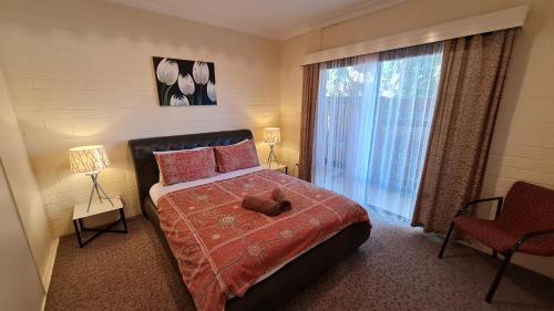 ein Schlafzimmer mit einem Bett mit einem Teddybär drauf in der Unterkunft Rise n' Shine - min stay 4 nights in Port Pirie