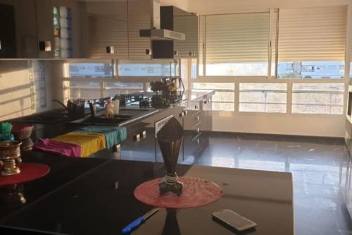 a kitchen with a table with a lamp on a counter at Superbe appartement meublé à louer avec piscine in El Harhoura