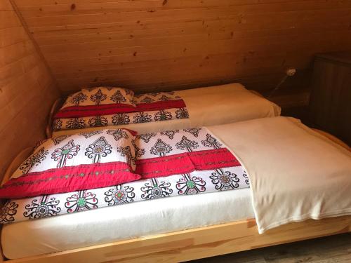 two beds in a wooden room withskirts at U Bartków in Kościelisko