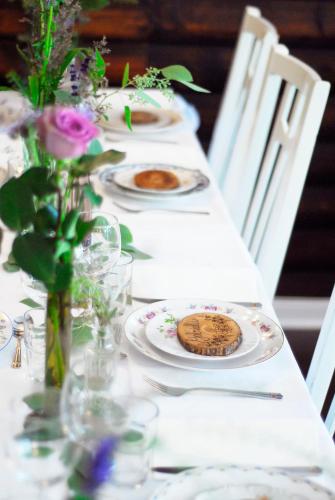 a table with plates of food and flowers on it at Furuliden Country Inn in Vittsjö