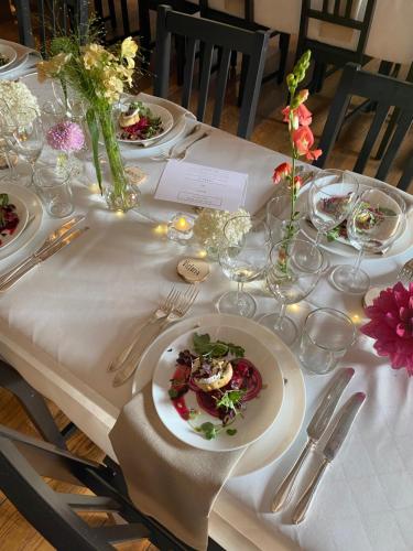 a table with plates of food and flowers on it at Furuliden Country Inn in Vittsjö