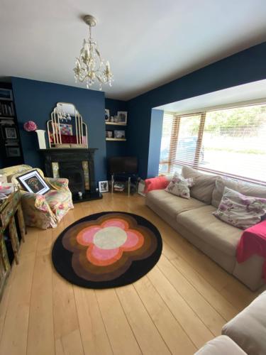 a living room with a couch and a rug on the floor at Summer Cottage in Kinsale in Kinsale