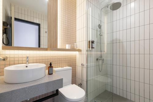 La salle de bains est pourvue de toilettes, d'un lavabo et d'une douche. dans l'établissement Wellesley Hotel, à Simpang Ampat