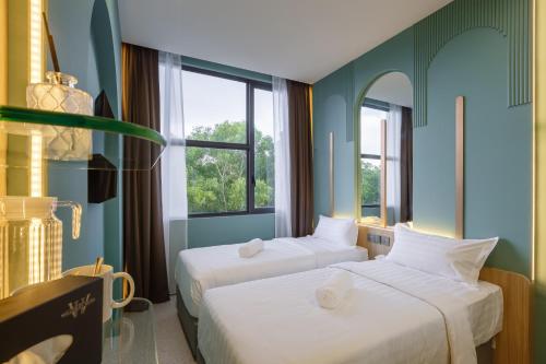 - 2 lits dans une chambre avec 2 fenêtres dans l'établissement Wellesley Hotel, à Simpang Ampat