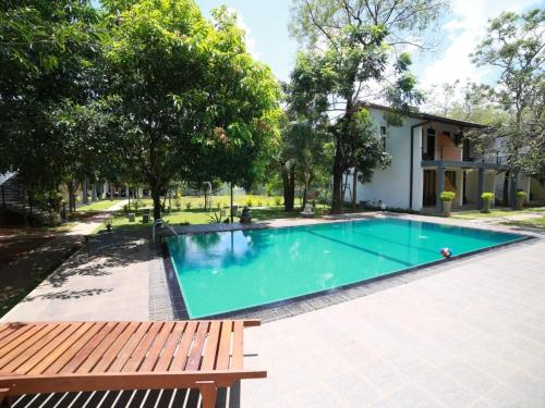 a swimming pool with a bench next to a house at Hotel Alakamanda in Anuradhapura