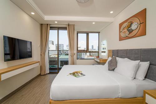 a hotel room with a large bed and a television at HSuites Riverside Hotel and Apartment in Danang