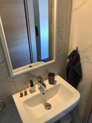 a white sink in a bathroom with a mirror at L&G ROOMS in Ljubljana