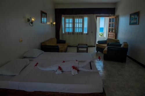 a bedroom with two beds and a living room at Happy Life Village Dahab in Dahab