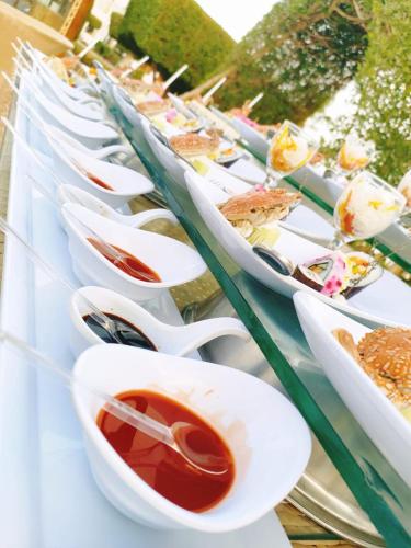 a long line of white bowls of food with spoons at Happy Life Village Dahab in Dahab