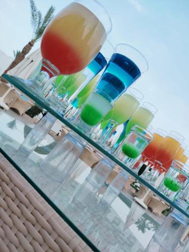 a glass table with different colored glasses on it at Happy Life Village Dahab in Dahab
