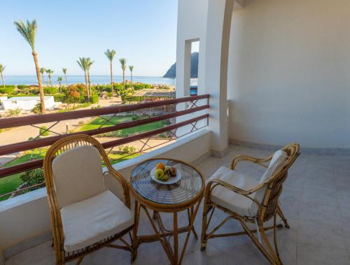 a balcony with a table and chairs and a view of the ocean at Happy Life Village Dahab in Dahab