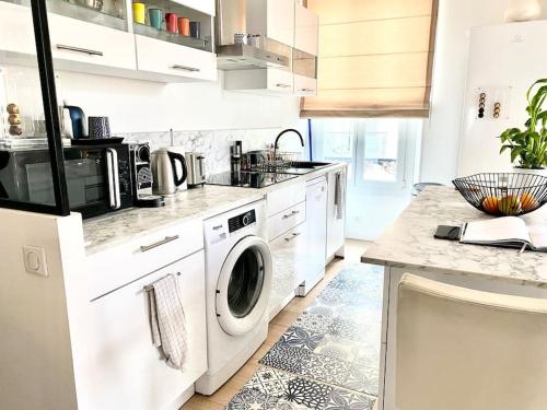 eine weiße Küche mit Waschmaschine und Trockner in der Unterkunft Paca Properties -12CV- T2 Cosy in Cannes