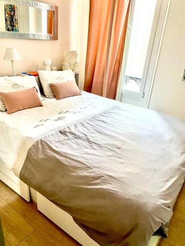 ein großes weißes Bett in einem Zimmer mit Fenster in der Unterkunft Paca Properties -12CV- T2 Cosy in Cannes