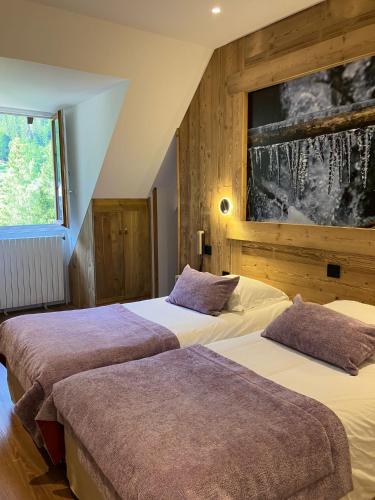 deux lits dans une chambre avec un tableau au mur dans l'établissement Chateau De La Muzelle, à Vénosc