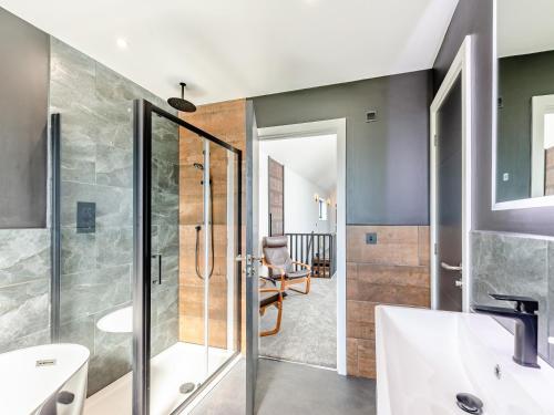 a bathroom with a glass shower and a sink at The Black Barn in Marldon